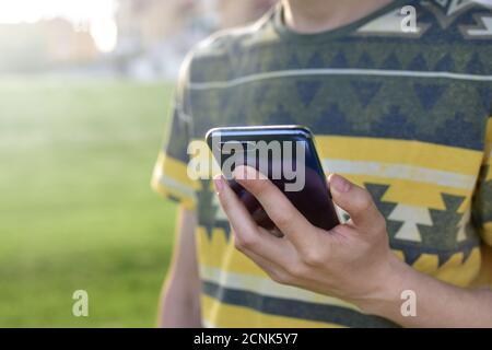 Close up view of male hands typing text message outdoors.Young businessman writes sms Stock Photo