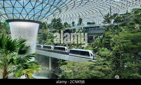 SINGAP, SINGAPORE - Jan 26, 2020: Sky trains passing roof waterfall at 'Jewel' area, Terminal 1, Changi airport, Singapore on January 26, 2020 Stock Photo