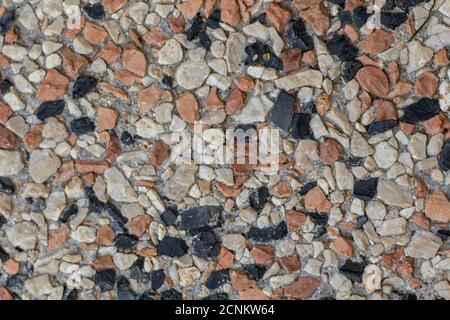 background of stones of various sizes and colors scattered on the ground Stock Photo
