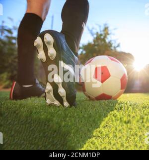 Female soccer football. Woman player ready to kick the ball on the grass, closeup view  on the feet Stock Photo