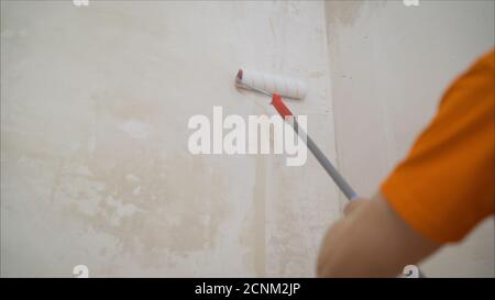 A Man Applies Wallpaper Glue With Brush For Wallpapering Repair Of