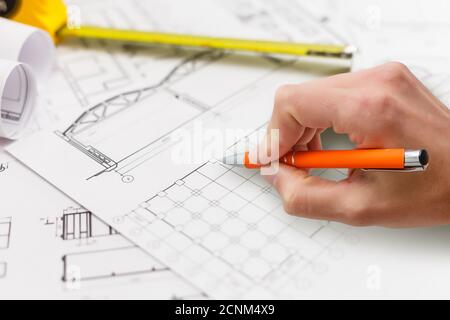 Plan of a house with a ruler and a hand writing with a pencil Stock Photo