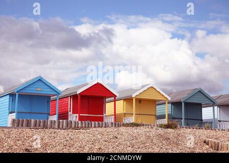 Primary coloured, red, yellow, blue row of beach huts at English seaside beach, Calshot, Hampshire. Stock Photo