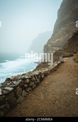 Santo Antao, Cape Verde - Sandy trail hike path from Cruzinha da Garca to Ponta do Sol. Moody Atlantic coastline with ocean waves. Stock Photo