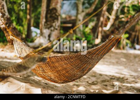 Young woman relaxing in a hammock on the beach during summer holiday. Stock Photo