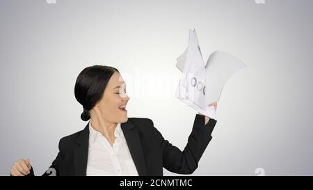 Excited business woman dancing with a bunch of papers in her han Stock Photo