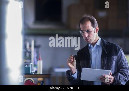 Engineer inspecting a machine part in an industrial plant, Germany Stock Photo