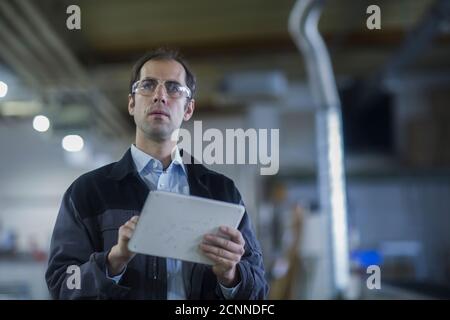 Engineer using a digital tablet in a factory, Germany Stock Photo
