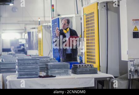 Engineer inspecting a machine part in an industrial plant, Germany Stock Photo
