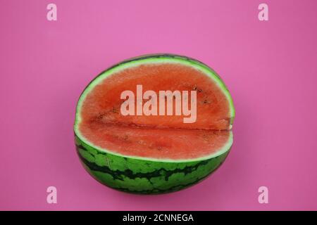 View on cut fresh ripe red and green watermelon on blank pink background Stock Photo