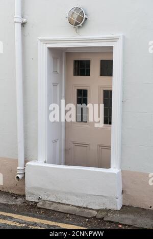 House with permanent high barrier in front of the door to protect the property from tidal flooding near the sea, UK Stock Photo