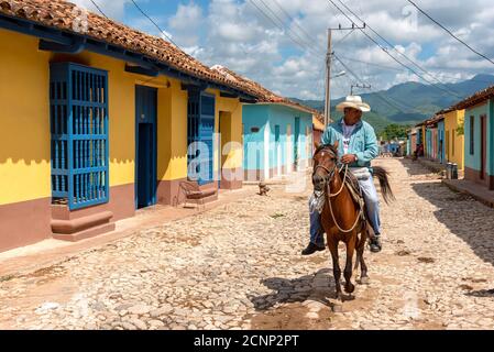 August 24, 2019: Man riding horse in the colored streets of Trinidad. Trinidad, Cuba Stock Photo