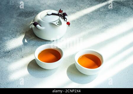 Two cups of tea and a teapot on a table Stock Photo