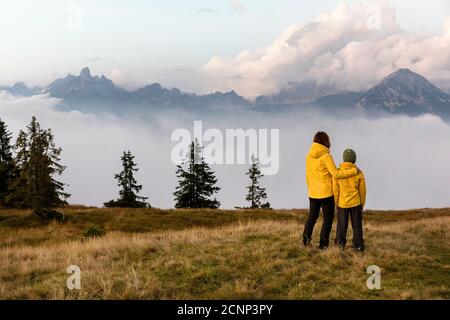 Mother and son standing on the Rossbrand mountain looking at peaks standing from fog Stock Photo