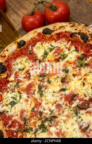 Pizza Margarita or Margherita with Tomatoes, Mozzarella Cheese, Tomato Sauce and basil. Traditional napoletana pizza on Wooden table Stock Photo