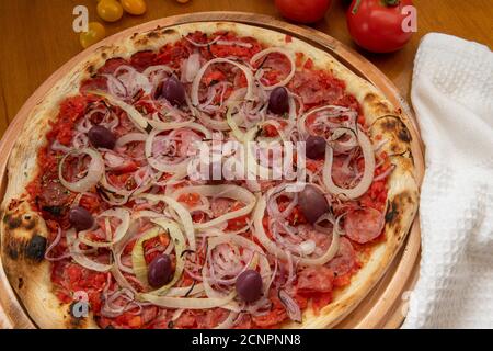 Pizza de Calabresa, Brazilian food. Calabrese sausage pizza with mozzarella cheese, onion, olives and tomato sauce. Traditional pizza in Brazil, it is Stock Photo
