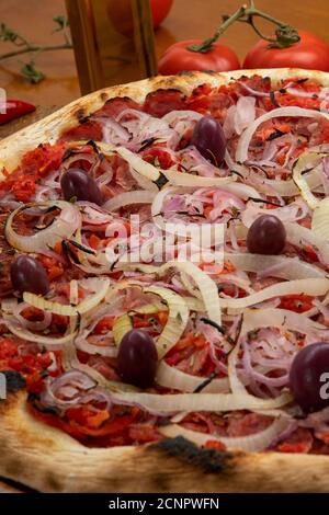 Pizza de Calabresa, Brazilian food. Calabrese sausage pizza with mozzarella cheese, onion, olives and tomato sauce. Traditional pizza in Brazil, it is Stock Photo