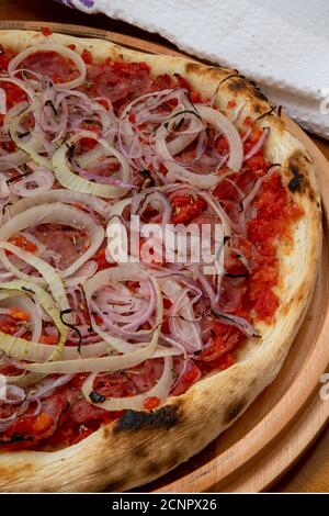 Pizza de Calabresa, Brazilian food. Calabrese sausage pizza with mozzarella cheese, onion and tomato sauce. Traditional pizza in Brazil, it is similar Stock Photo