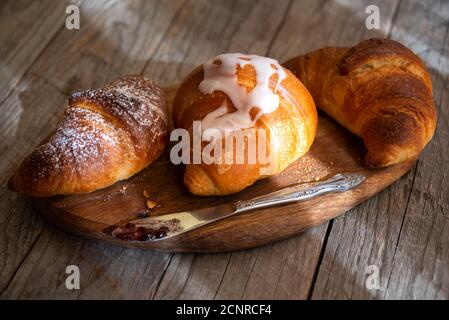Fresh baked sweet croissants with jam or honey for breakfast Stock Photo