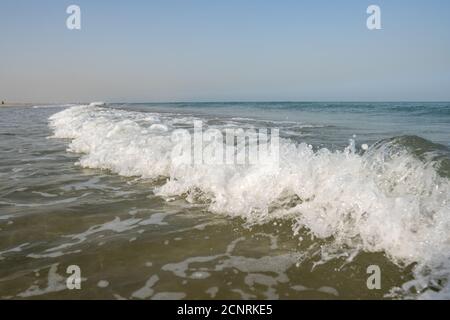 Crashing white waves and blue water and sky from the ocean or sea in the tropical warm holiday climate. Stock Photo