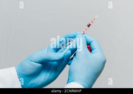 Doctor makes the vaccination, hold in hand an insulin syringe. Stock Photo