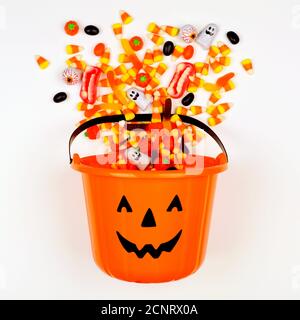 Halloween Jack o Lantern pail with spilling candy, above view on a white background Stock Photo