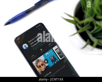 Lod, Israel - July 8, 2020: Modern minimalist office workspace with black mobile smartphone with Discord app play store page on white background. Top Stock Photo