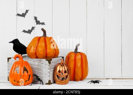 Halloween display with jack o lantern decor and pumpkins against a rustic white wood background. Copy space. Stock Photo
