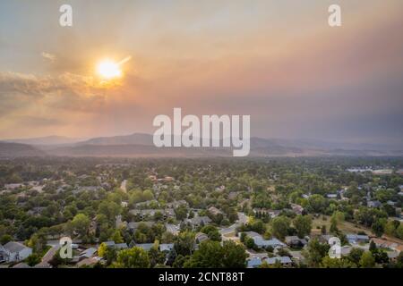 wildfire smoke from Cameron Peak Fire (September 2020) over Fort Collins and Front Range of Rocky Mountains in northern Colorado,  aerial view Stock Photo