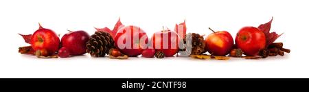 Autumn border of apples, leaves, and fall decor. Side view isolated on a white background. Stock Photo