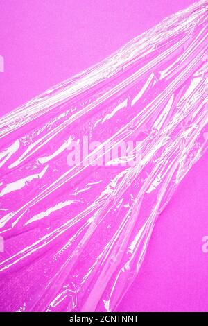 Stretch wrap plastic on pink background, minimalistic creative layout, ecology and environment concept Stock Photo