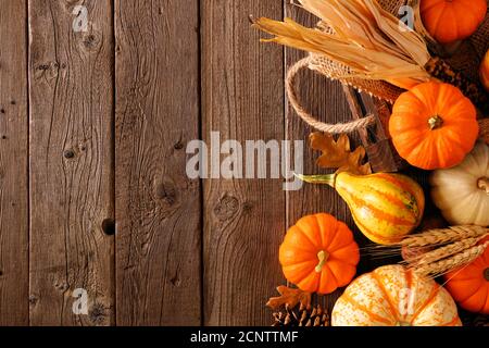 Fall side border of pumpkins, gourds and fall decor with harvest basket on a rustic wood background with copy space Stock Photo