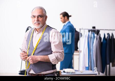 Young businessman visiting old tailor Stock Photo