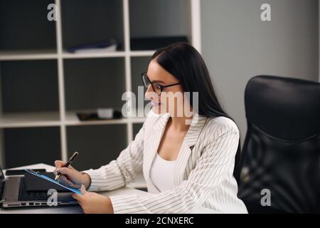 Focused woman working at her computer. Background for office startup Stock Photo