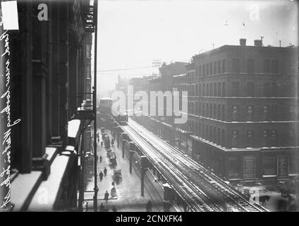 Lake Street looking west from a vantage point above the elevated tracks toward an elevated train rounding a corner, Chicago, Illinois Stock Photo