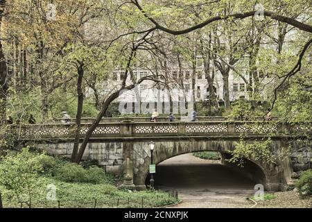 Greyshot Arch bridge with blurry runners in Central Park, Manhattan Stock Photo