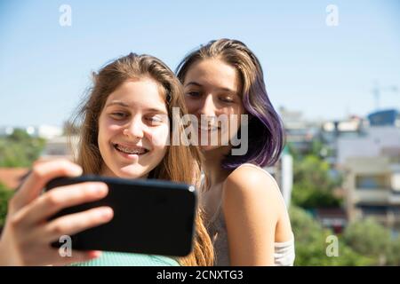 Two Teenage Girls Taking Selfie With A Mobile Phone. Home Concept Stock Photo