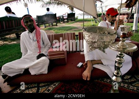 Saudi men smoke water pipe as they sit on a beach in Jeddah city in Saudi Arabia April 14, 2005. REUTERS/Ahmed Jadallah  AJ/TZ