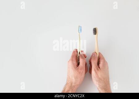 Choose eco material. Hands with two toothbrushes on white background. Stock Photo