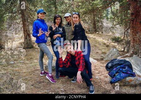 Group of people walking in mountains forest. International mountain day. Bishkek, Kyrgyzstan - April 9, 2019 Stock Photo