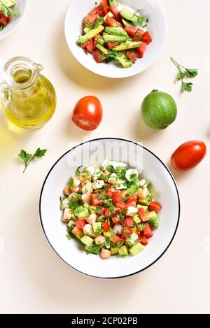 Avocado, prawn, tomato and mozarella salad with greens in bowl over light stone background. Healthy diet food concept. Top view, flat lay Stock Photo