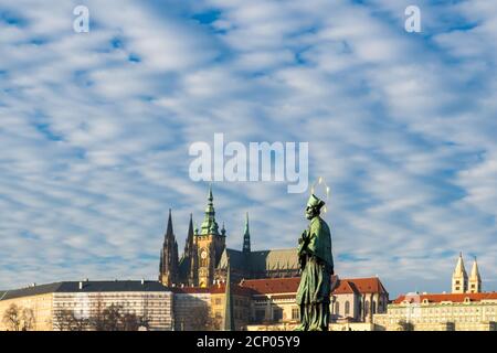 Sculpture of Jan Nepomutsky against a blue sky on Charles Bridge in winter Prague Stock Photo