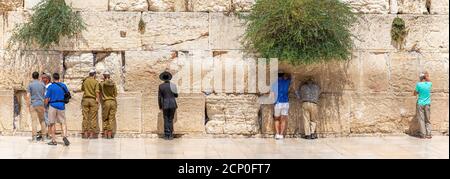 Jerusalem, Israel - Jewish orthodox believers reading the Torah and praying facing the Western Wall, also known as Wailing Wall in th Stock Photo