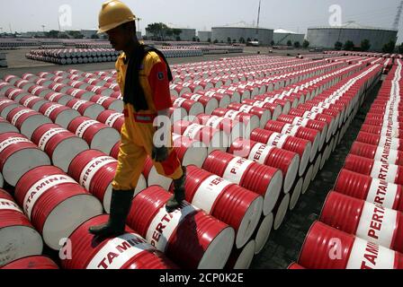 An employee of Indonesian oil company Pertamina walks on the top of drums at the oil storage depot in Jakarta September 1, 2005. Indonesia's state oil company Pertamina increased prices of high octane gasoline by more than 40 percent and hiked the prices of some other industry fuels on Thursday to catch up with the rising cost of crude oil. REUTERS/Beawiharta  BEA/PN