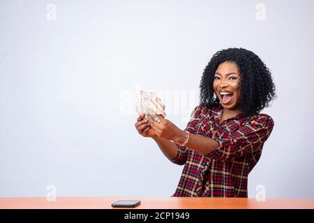 beautiful african lady holding some cash feeling excited and happy Stock Photo