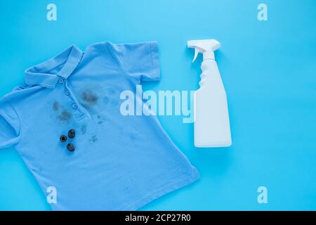 dirty black olive stains on clothes and stain removers. Stain cleaners.top view. Isolated on a blue background Stock Photo