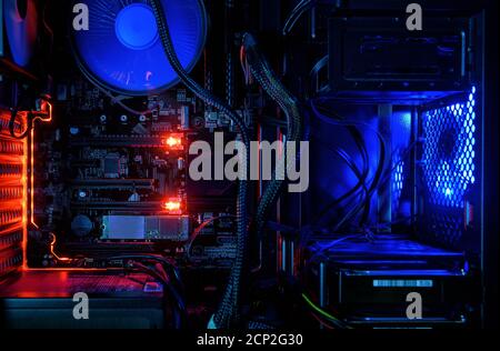 Computer with internal LED RGB lights and CPU cooling fans, hardware inside open high performance desktop PC. The open gaming computer for wallpaper. Stock Photo