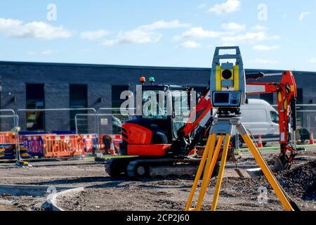 Yellow equipment set out on tripod on building site against cloudless ...