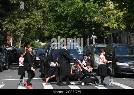 New York City, USA. 18th Sep, 2020. An Orthodox jewish family crosses Lee Ave. before the start of the jewish New Year “Rosh Hashanah. in the Williamsburg section of the Brooklyn borough of New York City, NY, September 18, 2020. Rosh Hashanah marks the first of the Jewish High Holy Days, is observed with celebrations, praying in synagogue, the sounding of the Shofar (ram's horn), and eating symbolic foods such as apples dipped in honey to evoke a sweet New Year. (Anthony Behar/Sipa USA) Credit: Sipa USA/Alamy Live News Stock Photo