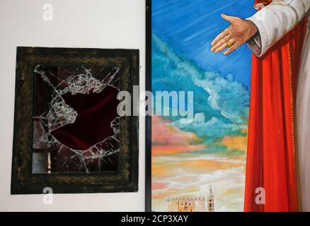 A broken glass of a niche where the reliquary with the blood of the late Pope John Paul II was located is seen next to a painting of the late Pope in the small mountain church of San Pietro della Ienca, near the city of L'Aquila January 28, 2014 .Thieves broke into a small church in the mountains east of Rome over the weekend and stole the reliquary with the blood of the late Pope John Paul II, a custodian said on Monday. Dozens of police with sniffer dogs scoured the remote area for clues to what the Italian Catholic magazine Famiglia Cristiana called 'a sacrilegious theft that was probably c